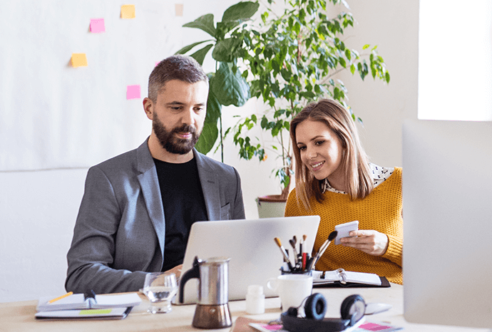 Male and female coworkers collaborating with laptop