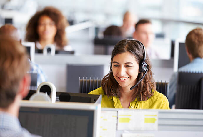 Woman smiling while on her headset and computer